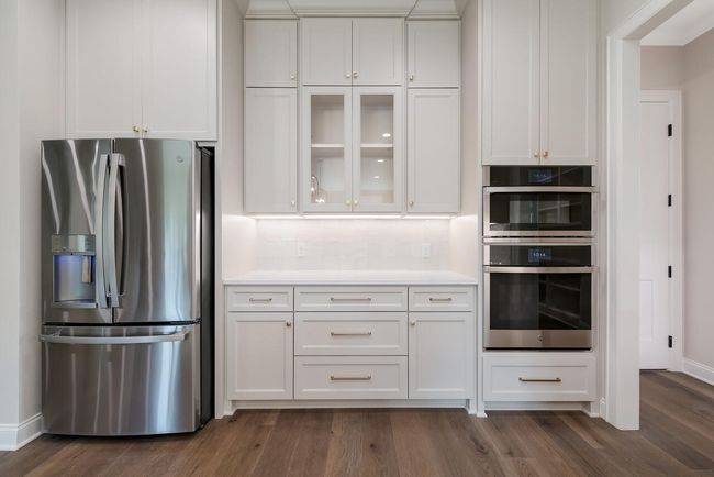 Kitchen featuring stainless steel appliances, white cabinetry, and dark wood-style floors | Image 18
