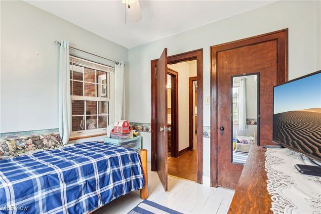 Bedroom with ceiling fan, multiple windows, and wood finished floors | Image 14