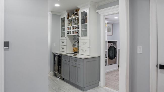 Laundry room featuring washer / clothes dryer, wine cooler, bar area, recessed lighting, and cabinet space | Image 13