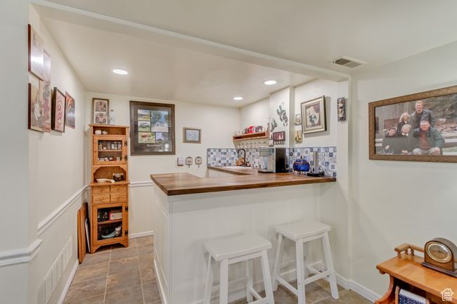 Bar with backsplash, a sink, visible vents, and recessed lighting | Image 39