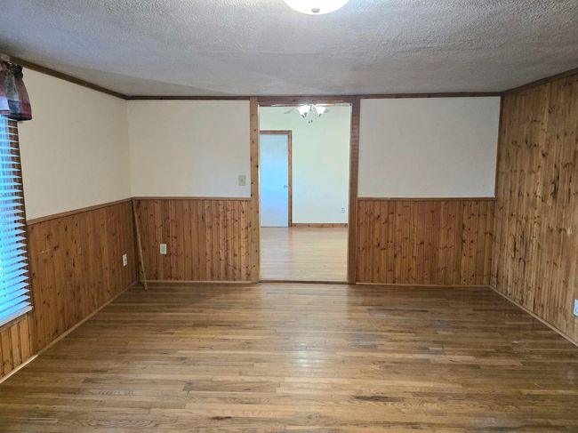 Unfurnished room featuring hardwood / wood-style flooring and wooden walls | Image 4
