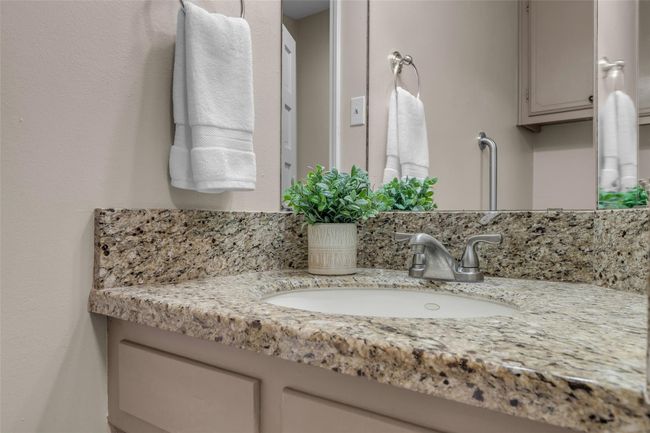 This half bathroom features a granite countertop with an undermount sink and a modern faucet. | Image 23