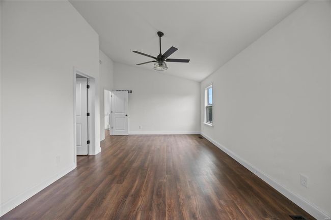 Unfurnished room featuring baseboards, ceiling fan, vaulted ceiling, and dark wood-style floors | Image 38