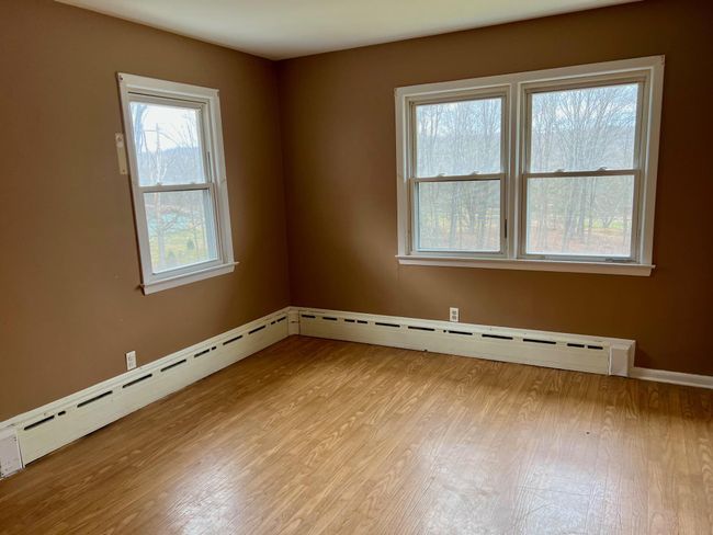 Unfurnished room featuring baseboards, a baseboard heating unit, and wood finished floors | Image 14