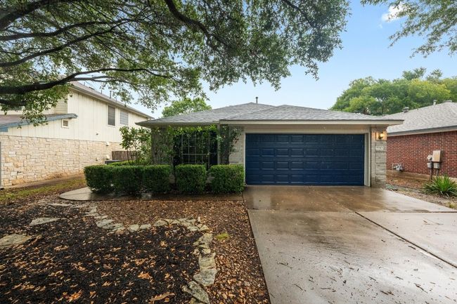 Ranch-style home with driveway, brick siding, and an attached garage. | Image 21