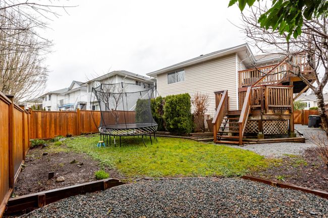 Rear view of house with stairs showcasing a deck for the main home and another deck for the suite | Image 38