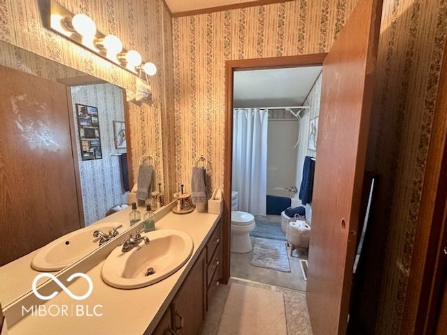 bathroom featuring wallpapered walls, vanity, a shower with shower curtain, and toilet | Image 14