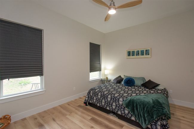 Bedroom with ceiling fan, light hardwood / wood-style floors, and multiple windows | Image 32