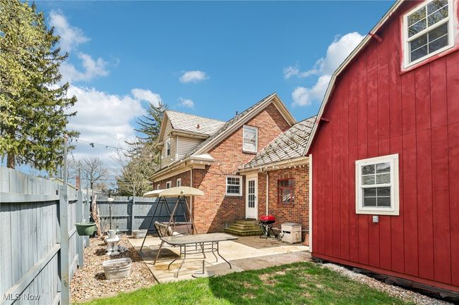 Rear view of property with a fenced backyard, brick siding, a patio, and entry steps | Image 30