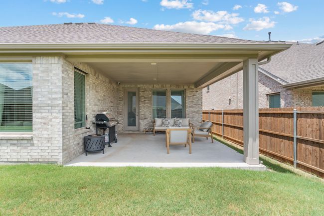 Rear view of property featuring brick siding, roof with shingles, and a patio | Image 30