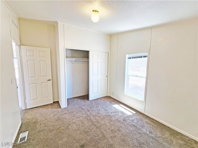 Unfurnished bedroom featuring a textured ceiling, visible vents, a closet, and carpet floors | Image 15