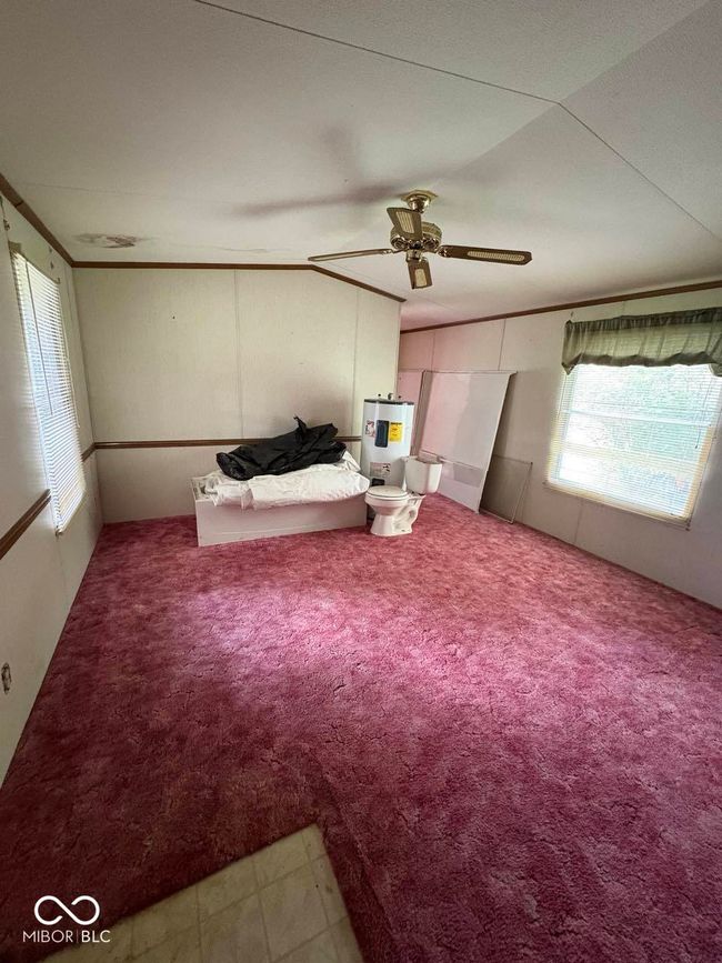 carpeted bedroom with water heater and ceiling fan | Image 14