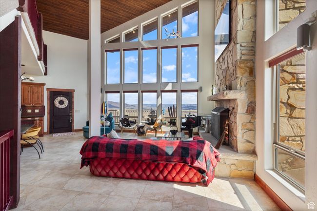 Living room with light tile patterned flooring, a mountain view, wood ceiling, and high vaulted ceiling | Image 5