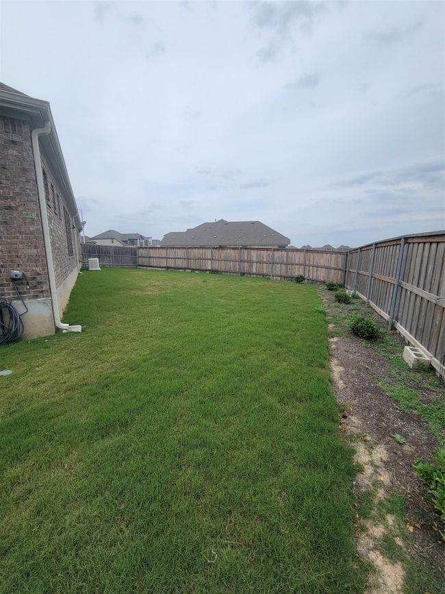 View of yard featuring a fenced backyard, and a generator | Image 14