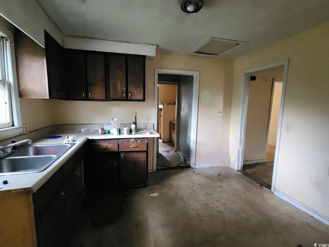 Kitchen featuring a sink, light countertops, and baseboards | Image 7