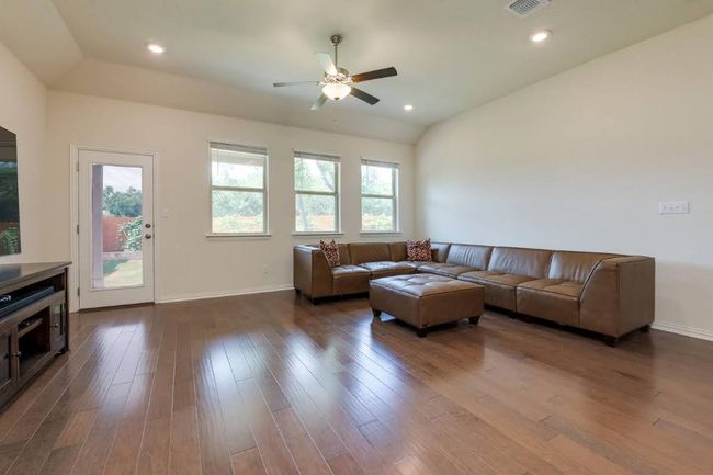 Living area with lofted ceiling, a ceiling fan, baseboards, dark wood-type flooring, and recessed lighting | Image 12