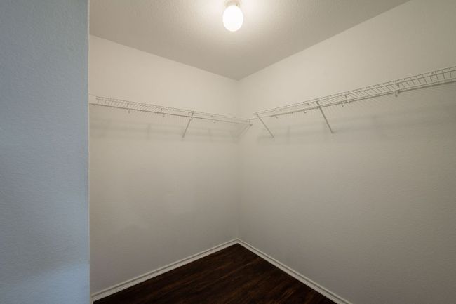 Spacious closet with dark wood-type flooring | Image 20