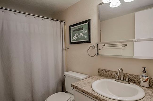 Full bathroom with vanity, toilet, and a shower with curtain | Image 8
