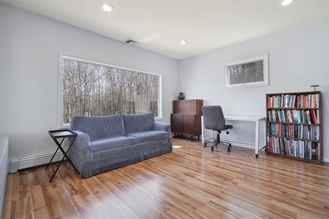 Office featuring wood finished floors, recessed lighting, a baseboard heating unit, and visible vents | Image 8