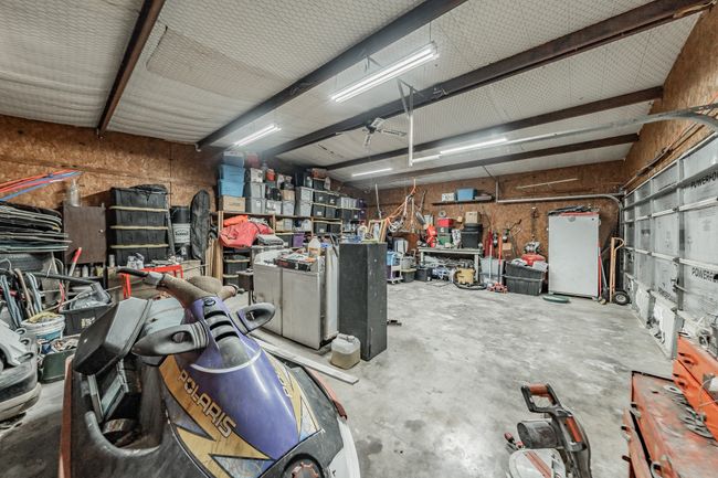 Garage featuring a creative workshop area and white fridge | Image 7