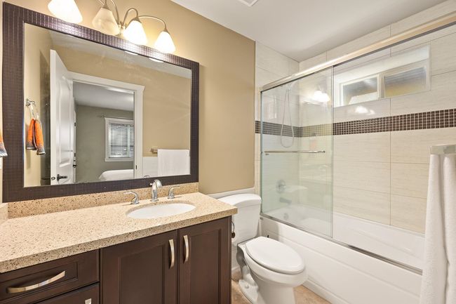 Bathroom featuring vanity and shower / bath combination with glass door | Image 26