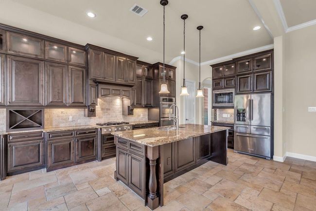 This gorgeous kitchen features rich wood cabinets with soft-close doors and drawers for a smooth, quiet experience. | Image 8