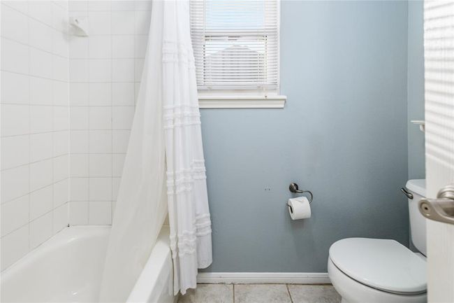 A shower/tub combo offers convenience in this bathroom | Image 32