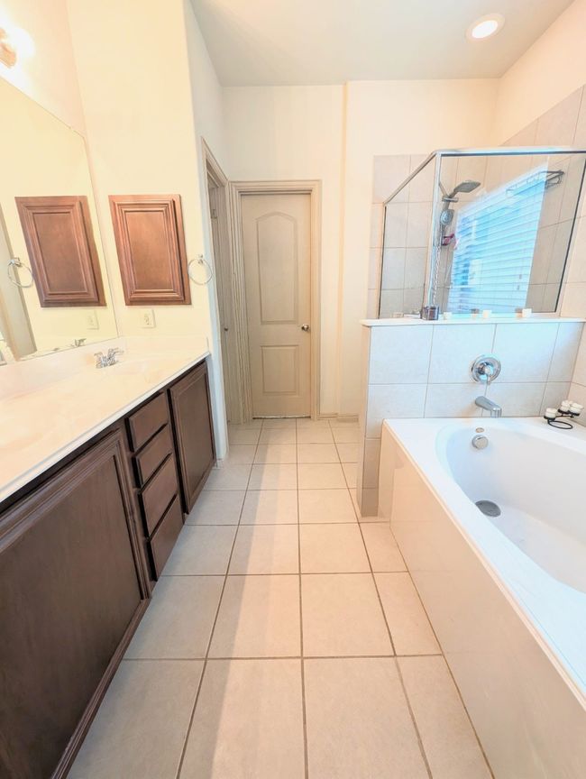 Bathroom featuring vanity, a bath, a shower stall, and tile patterned floors | Image 32
