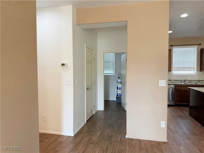 Corridor with dark wood-type flooring, baseboards, and a sink | Image 7