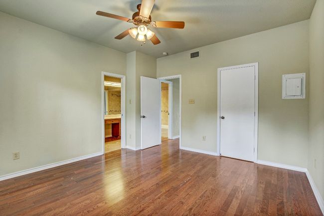 Bedroom with wood floors, ensuite bathroom, and a ceiling fan | Image 20