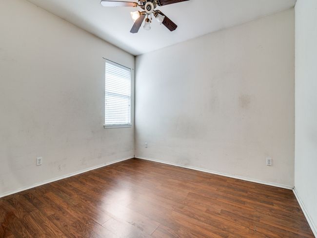 Empty room with wood finished floors, baseboards, and ceiling fan | Image 17