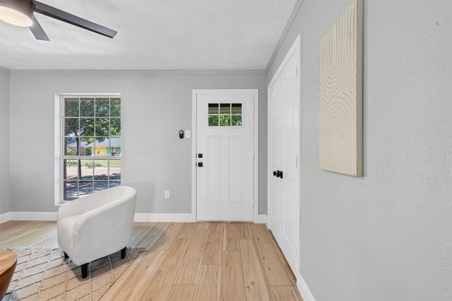 Entrance foyer with light wood-type flooring, ornamental molding, and a ceiling fan | Image 6