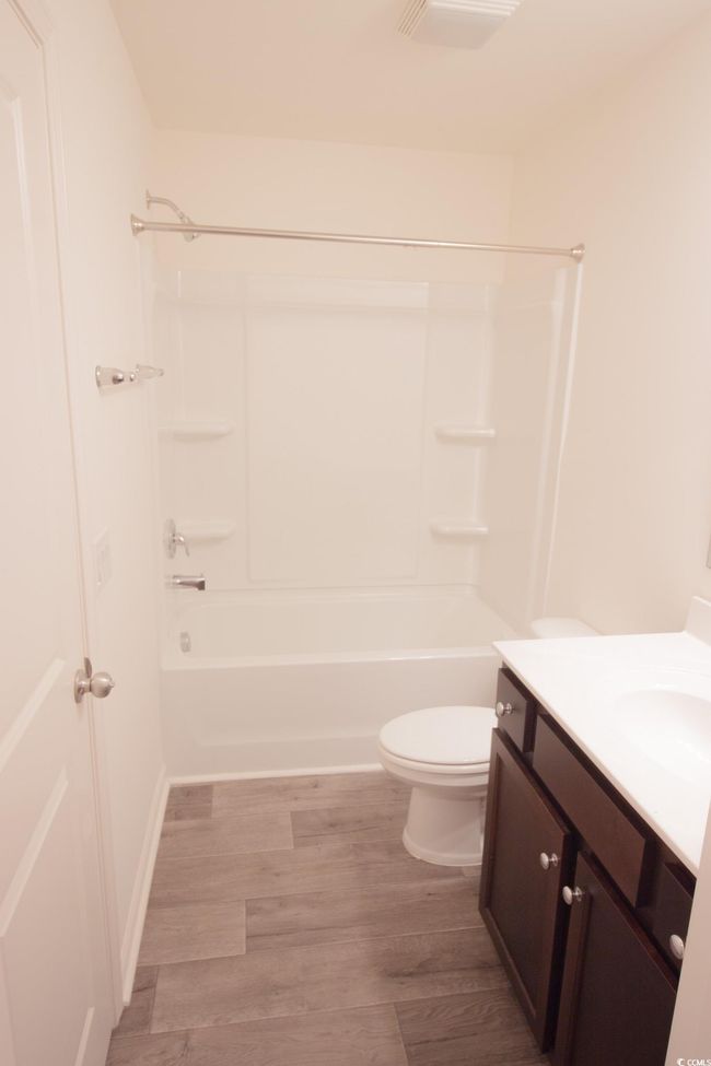 Full bathroom with vanity, wood finished floors, bathtub / shower combination, and toilet | Image 13