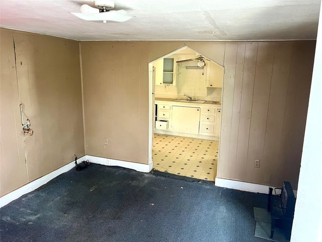 Unfurnished room with wooden walls and light colored carpet | Image 5