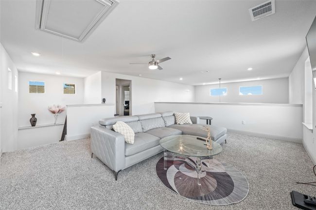 Carpeted living room featuring visible vents, baseboards, recessed lighting, and attic access | Image 18