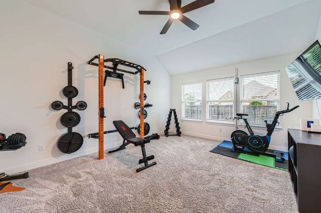 Exercise area featuring a ceiling fan, vaulted ceiling, and carpet | Image 26