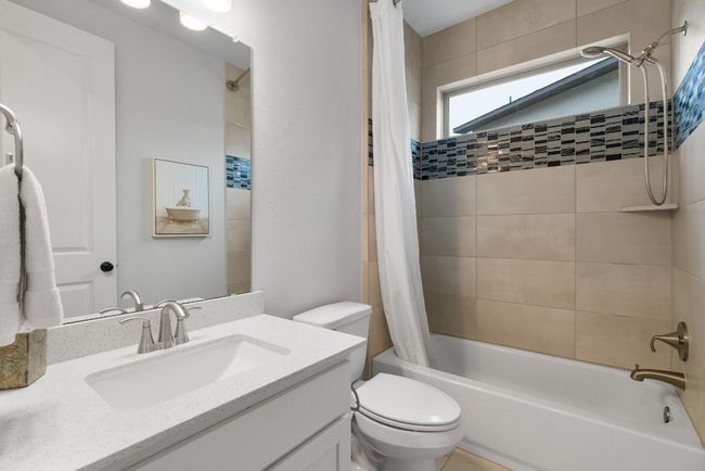 A full bathroom with tile flooring and a bathtub/shower combo. | Image 24