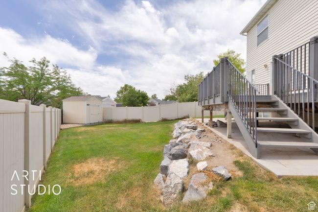 Fenced backyard featuring stairs, a wooden deck, and a storage shed | Image 24