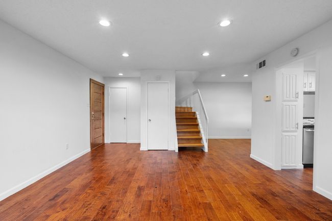 Living room and recessed lighting, wood-type flooring, and stairs | Image 8