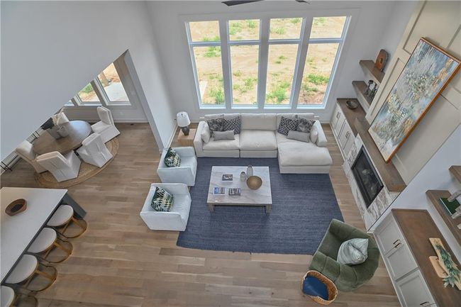 Living room featuring a high ceiling, ceiling fan, wood-type flooring, and a wealth of natural light | Image 34