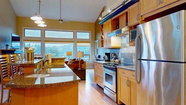 Kitchen with a sink, backsplash, range hood, stainless steel appliances, and light wood-style floors | Image 7