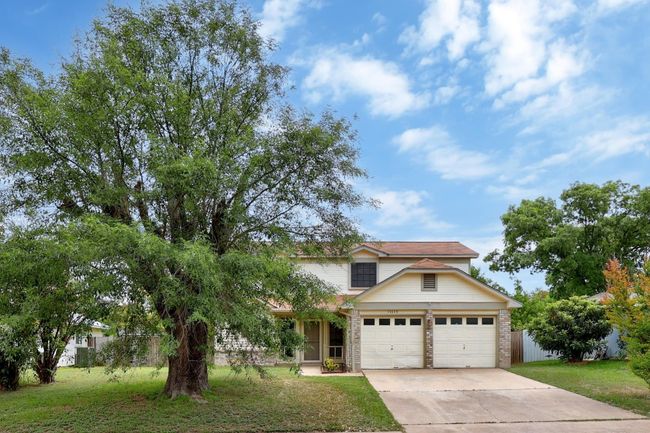 View of front of property featuring concrete driveway, a front lawn, brick siding, and a garage | Image 28