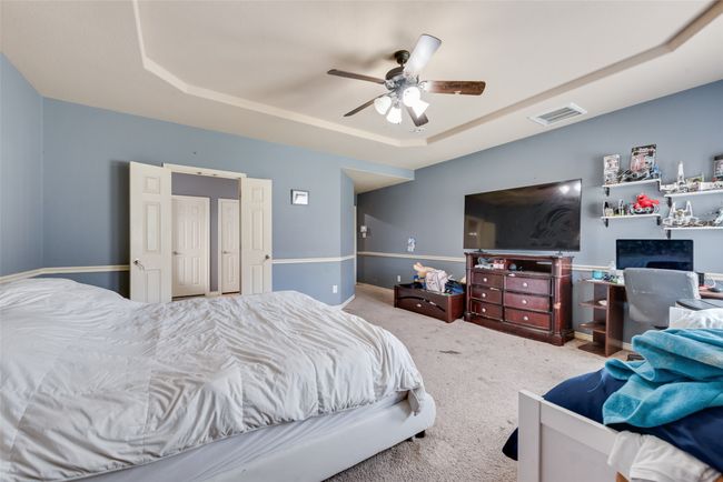 Carpeted bedroom featuring a tray ceiling and ceiling fan | Image 17