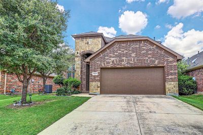 View of front facade with a front lawn, a garage, and central air condition unit | Image 2