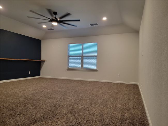 Carpeted empty room with a ceiling fan, lofted ceiling, recessed lighting, and baseboards | Image 22