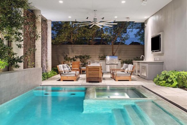 Closer view of the POOL with its spa - infinity edge, gunite, chlorine, heated! To the left is the perimeter pool wall with three water features. | Image 37