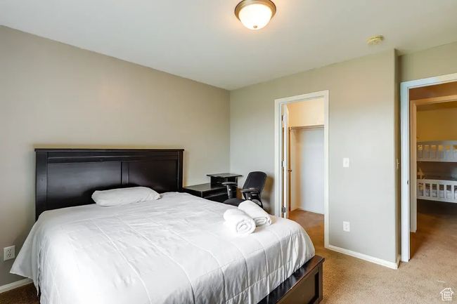 Bedroom featuring baseboards, a walk in closet, and carpet | Image 16