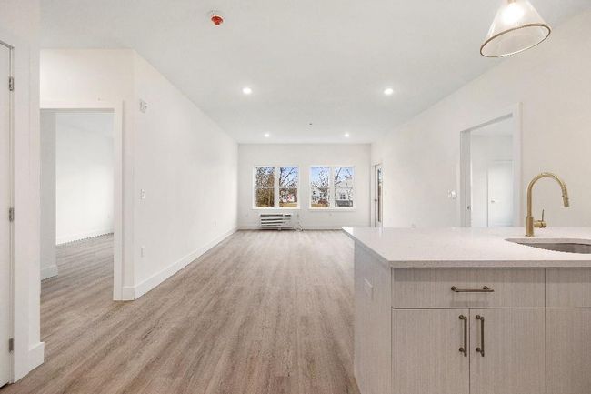 Unfurnished living room with a sink, light wood-type flooring, baseboards, and recessed lighting | Image 7