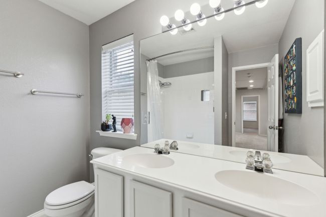 Bathroom featuring toilet, a shower with curtain, plenty of natural light, and double vanity | Image 27
