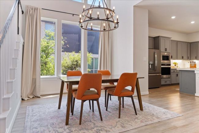 Dining area with a chandelier, light wood-style flooring, and a wealth of natural light | Image 6
